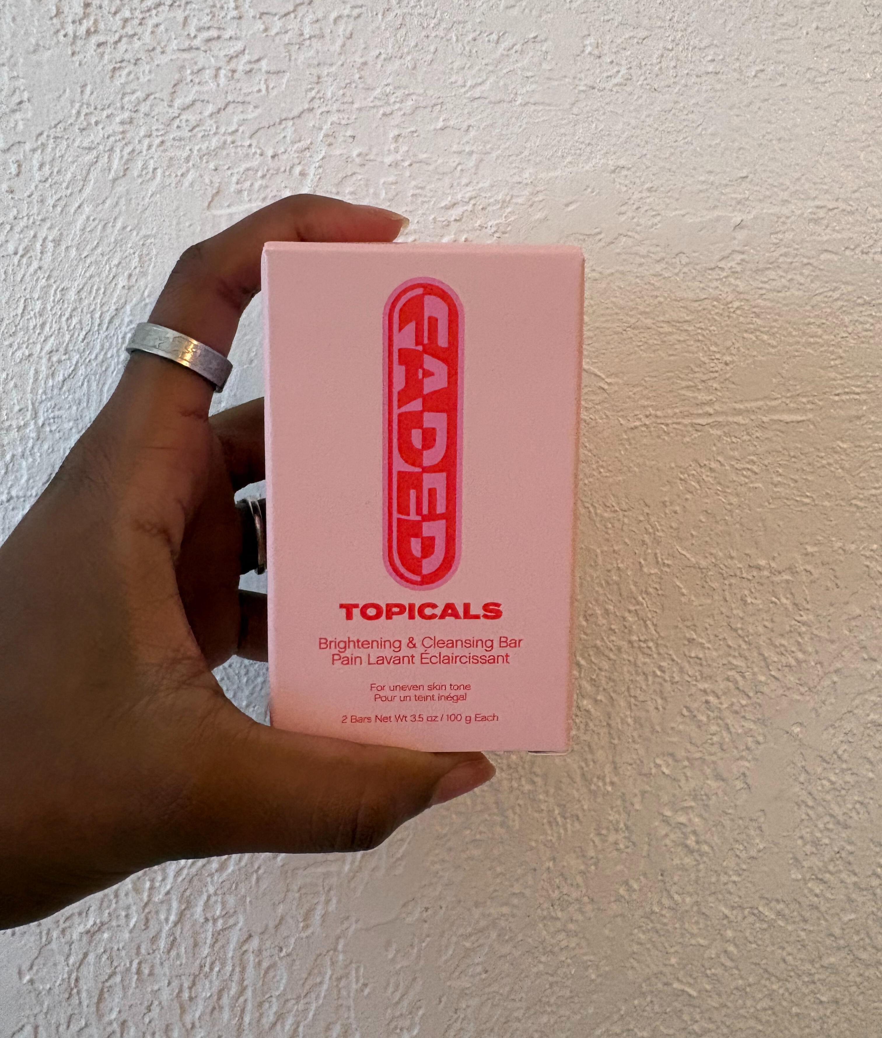 A photo of the 3.5 oz pink paper box container from Topicals advertising their Brightening & Cleansing bar
